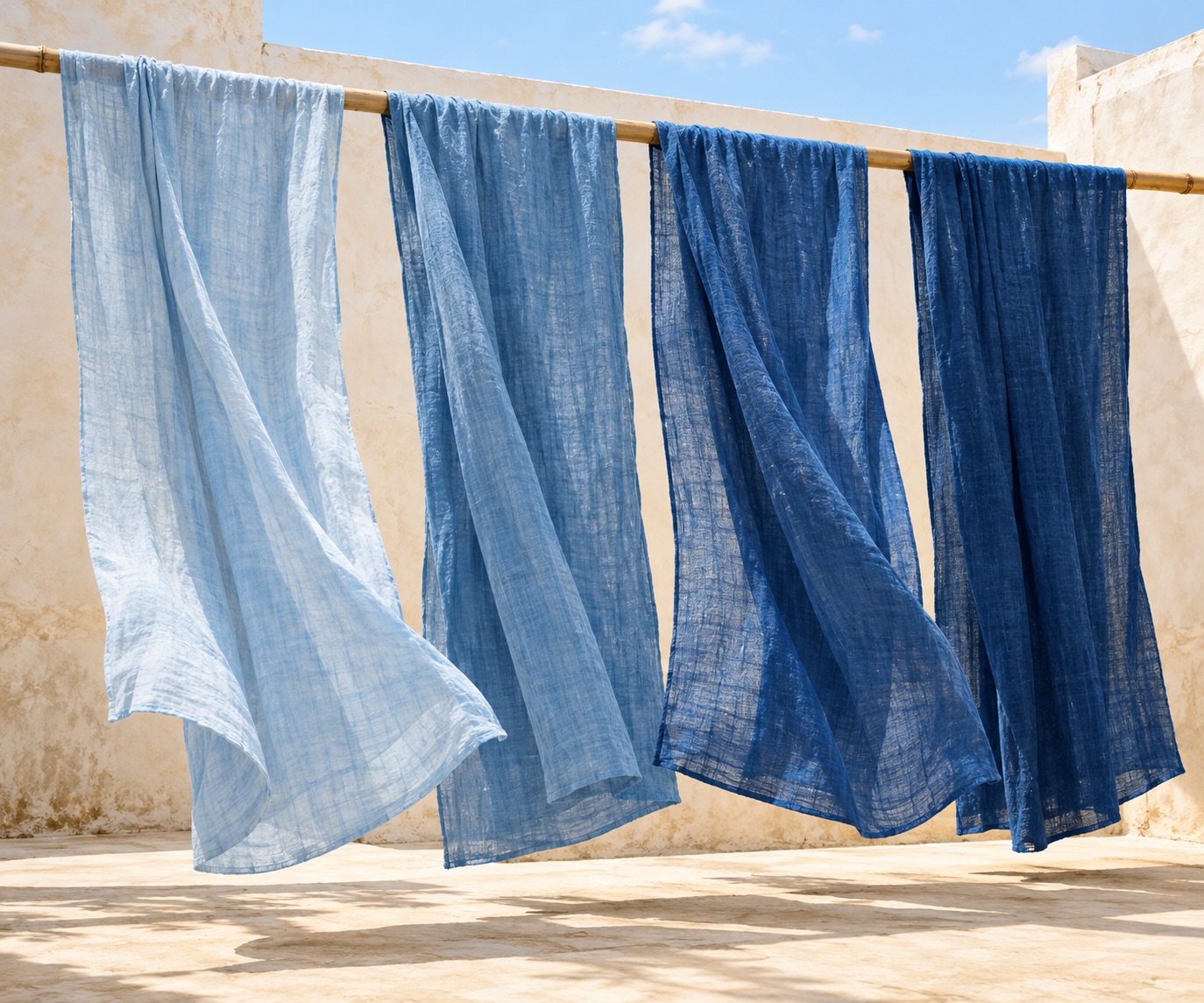 Sunlit indigo cloths drying in a bright courtyard