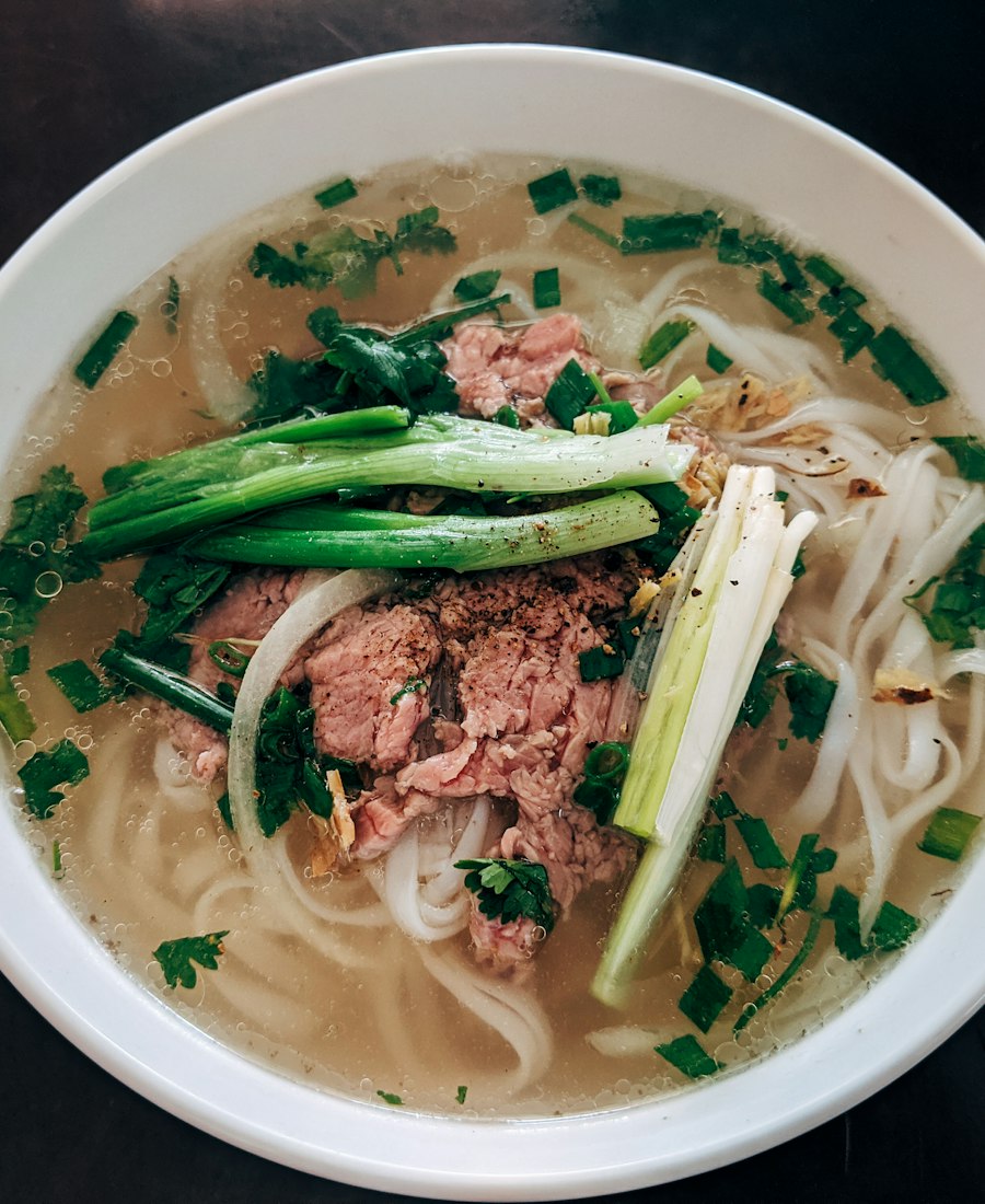 Bowl of phở with rare beef, rice noodles and spring onion